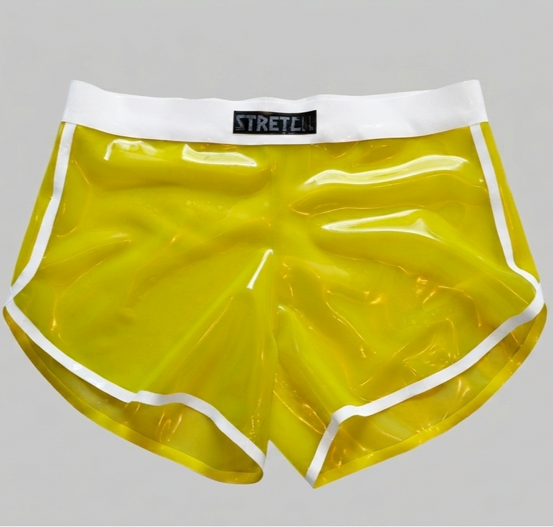 Yellow translucent latex shorts with a white waistband and white piping trim, featuring a black STRETCH label on the front.
